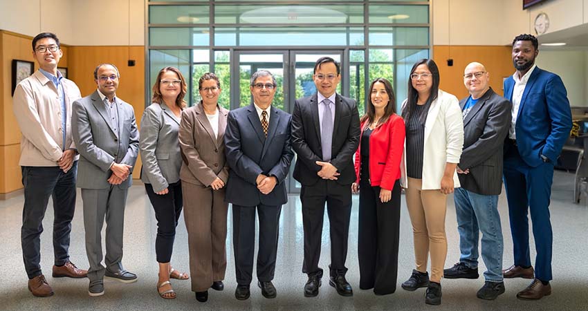 Group photo of accounting faculty and staff standing in the lobby of Au Sable Hall, home of the School of Business and Economics.