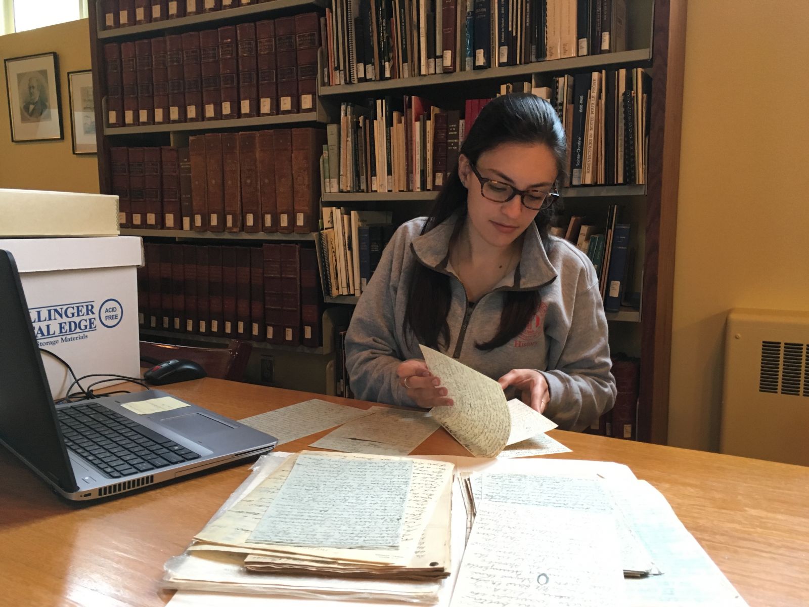 Samatha Jones looks over historic documents at Eastern Townships Resource Center in Canada